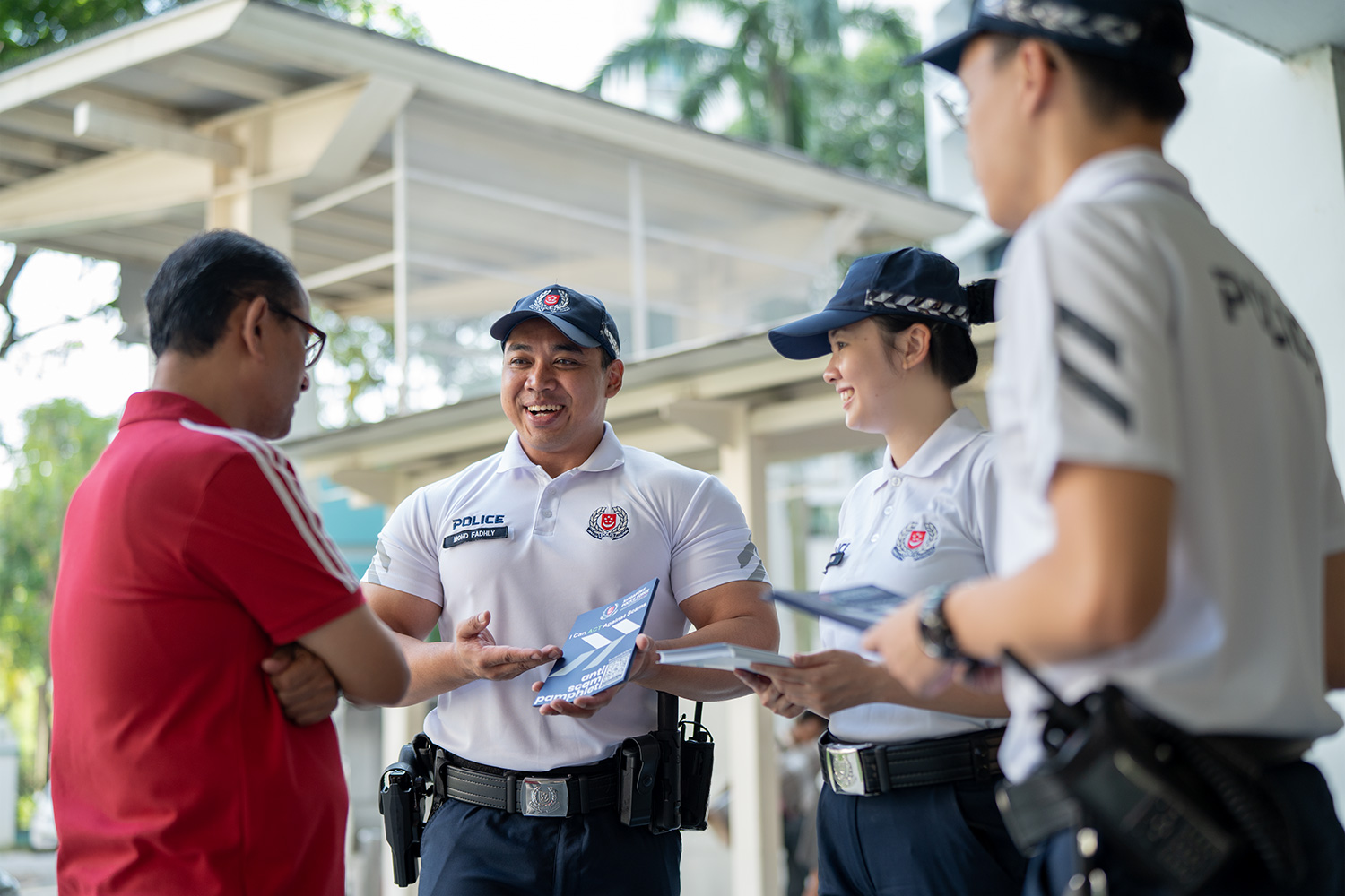 cpu officer with his colleagues interacting with a member of the public who is wearing orange