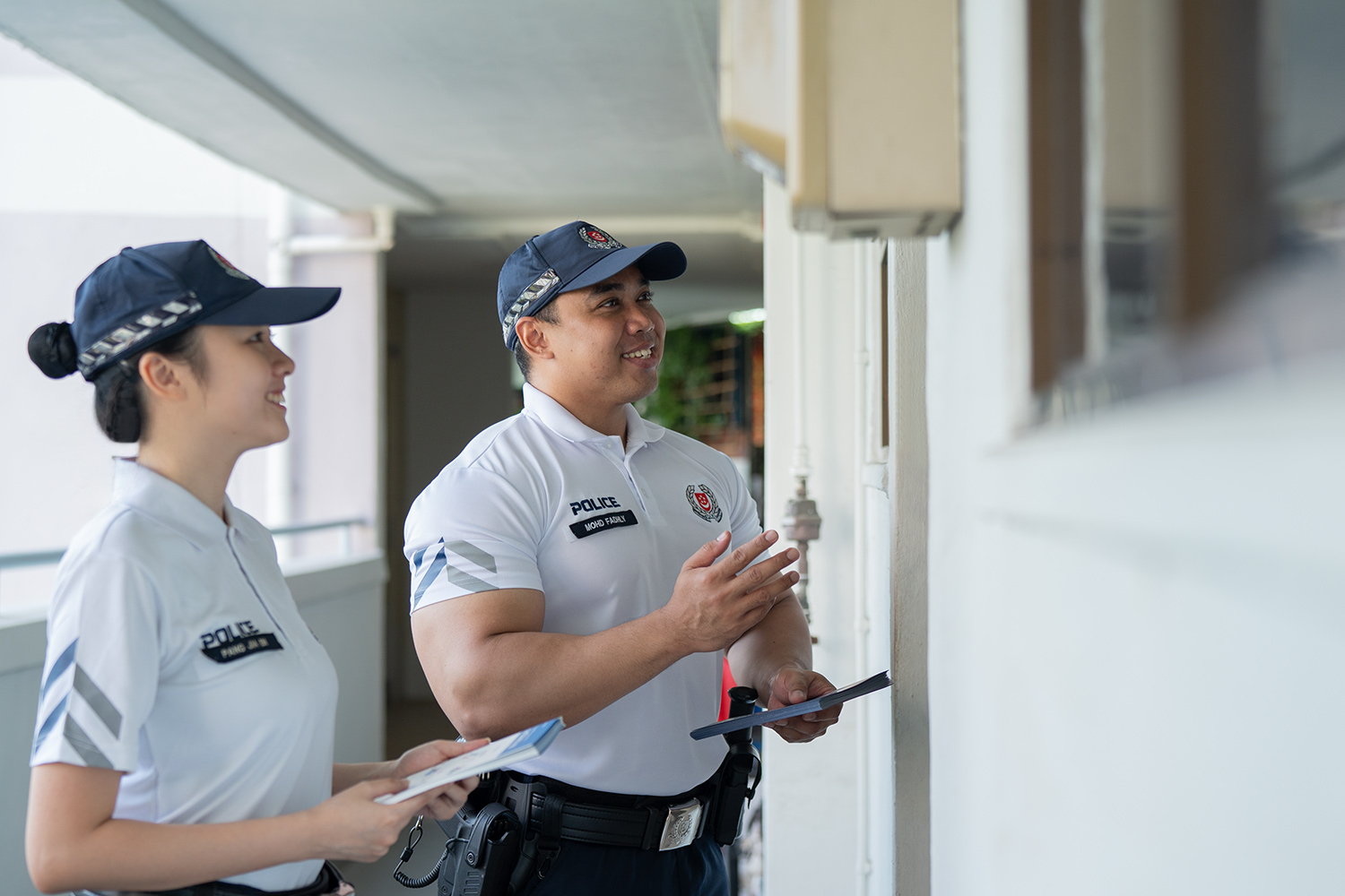 a male and female cpu officer talking to a resident in a house, outside their doorstep
