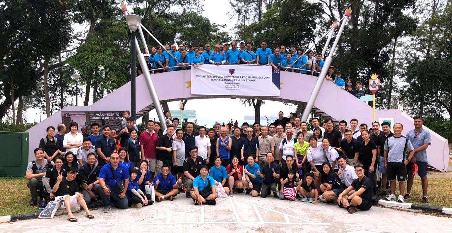 a big group photo of many people together at the park posing for the camera near to the road safety community park