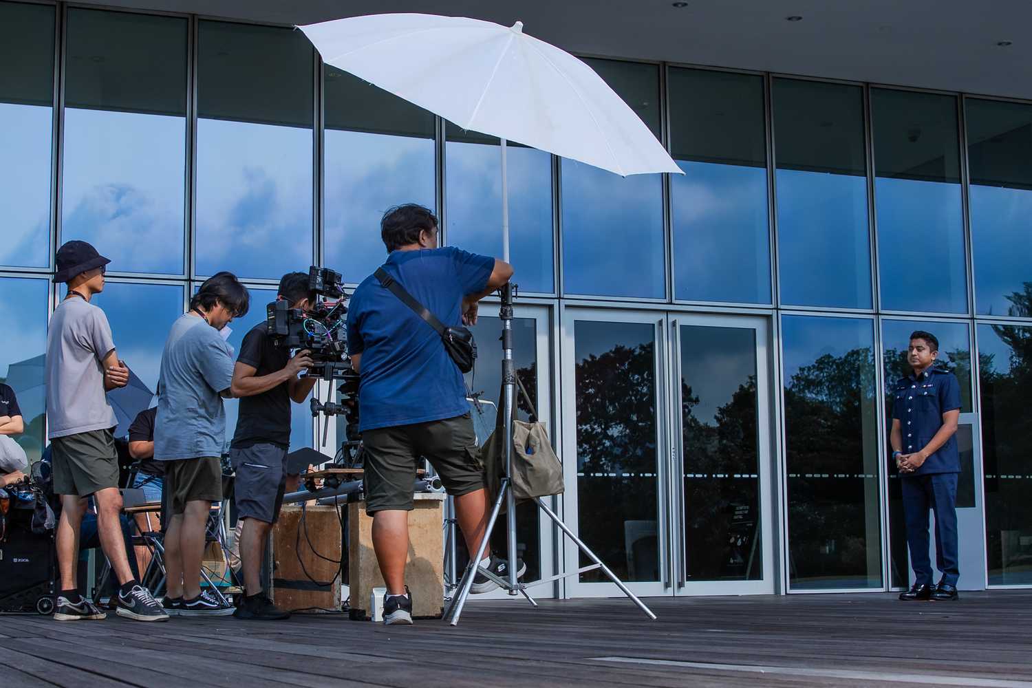 The crimewatch crew is in the midst of filming a Police host segment out in the open, in front of a building. 