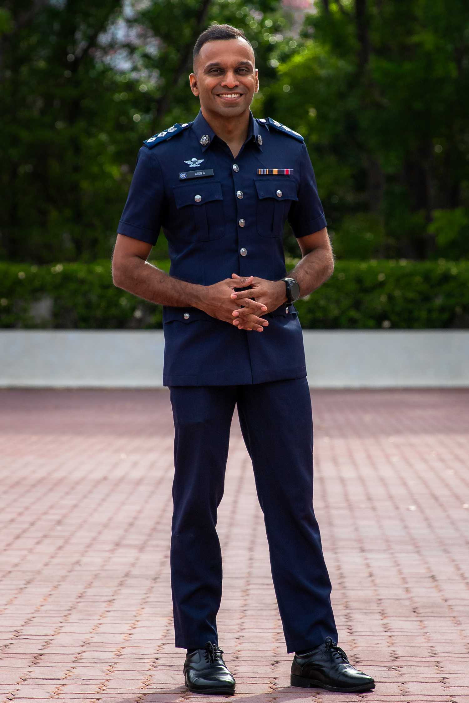 A profile shot of Superintendent of Police Arun Guruswamy in uniform, smiling and standing in front of the camera.