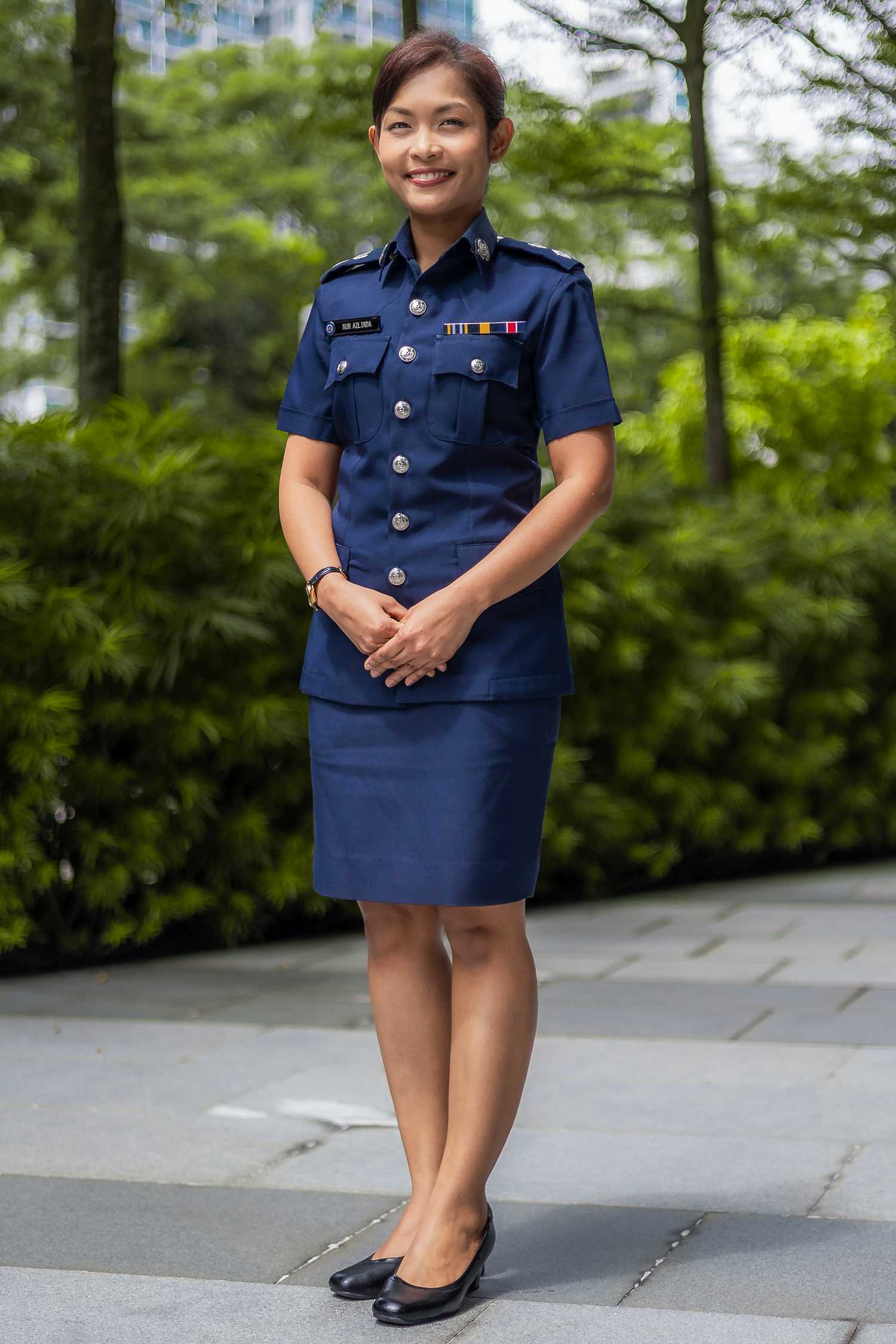 A profile shot of Deputy Superintendent of Police Azlinda Aziz in uniform, smiling and standing in front of the camera.