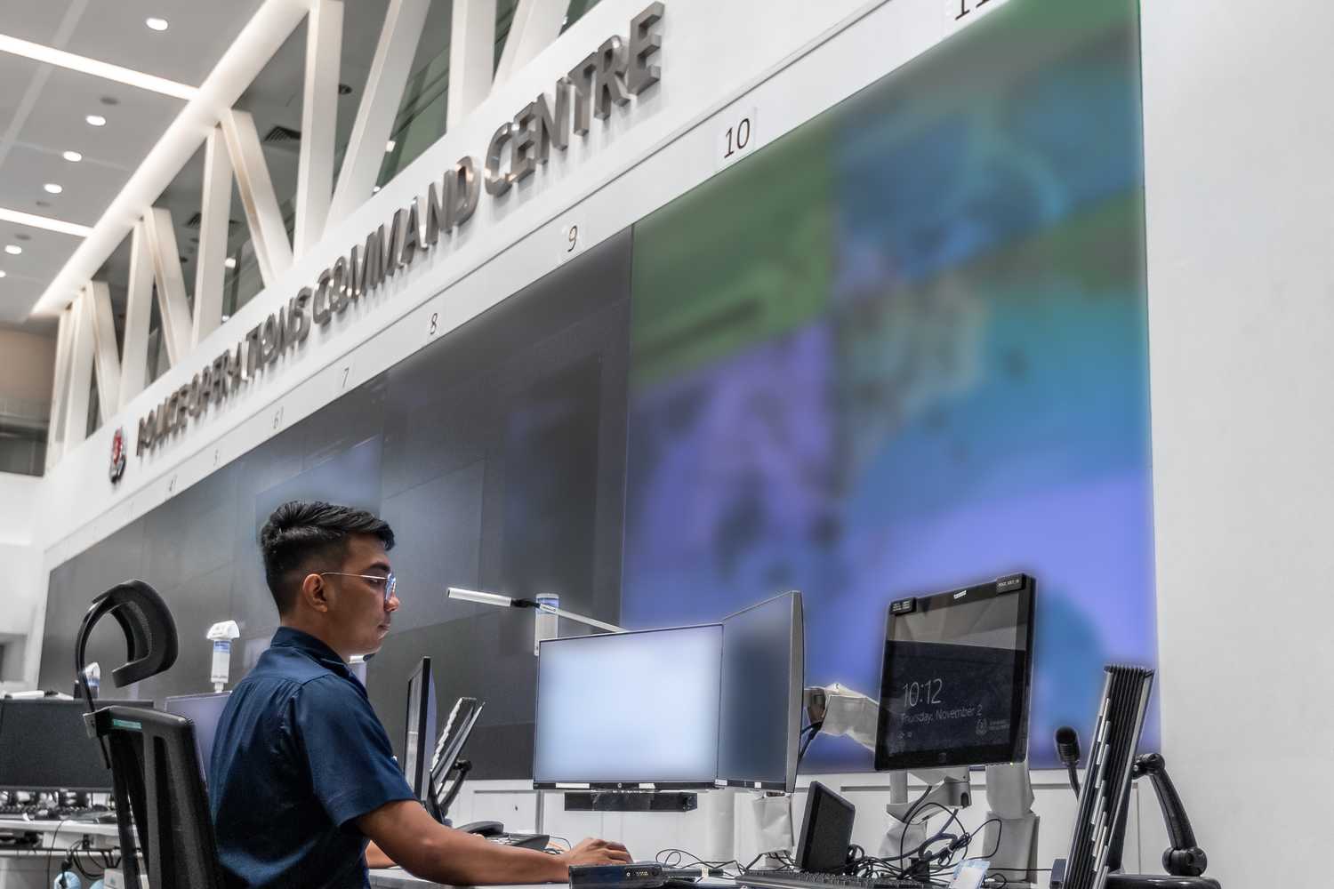 the PNSF sitting in POCC facing a big wall with multiple screens for POCC incident monitoring