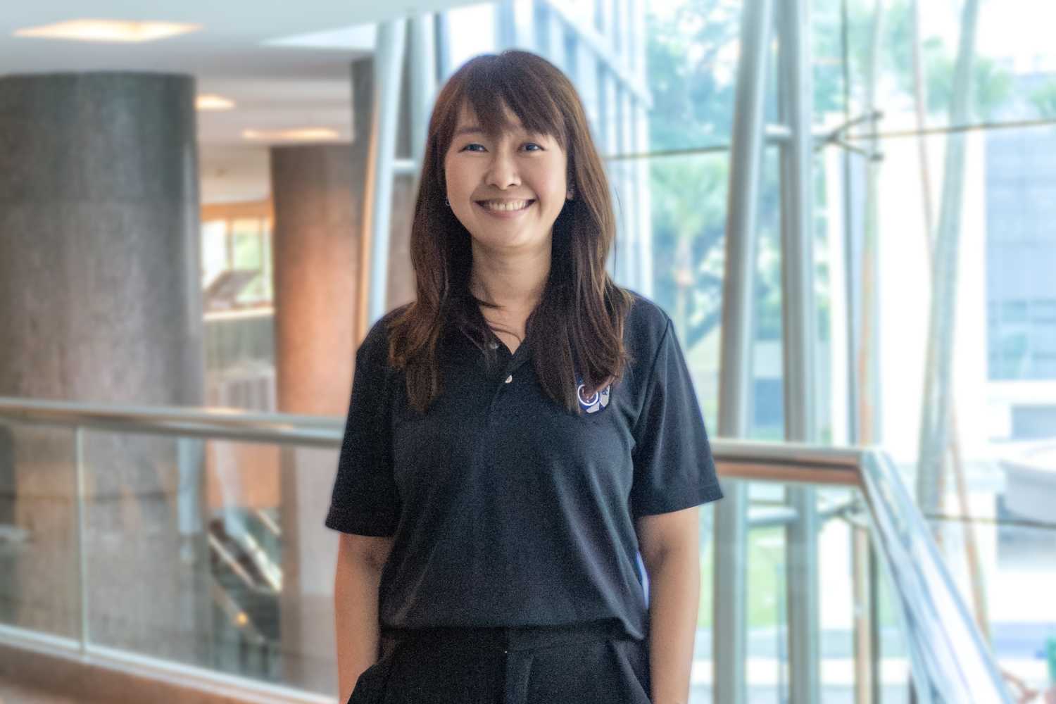 PPSD Principal Psychologist Ms Ho Hui Fen stands smiling in front of the camera in a profile shot.