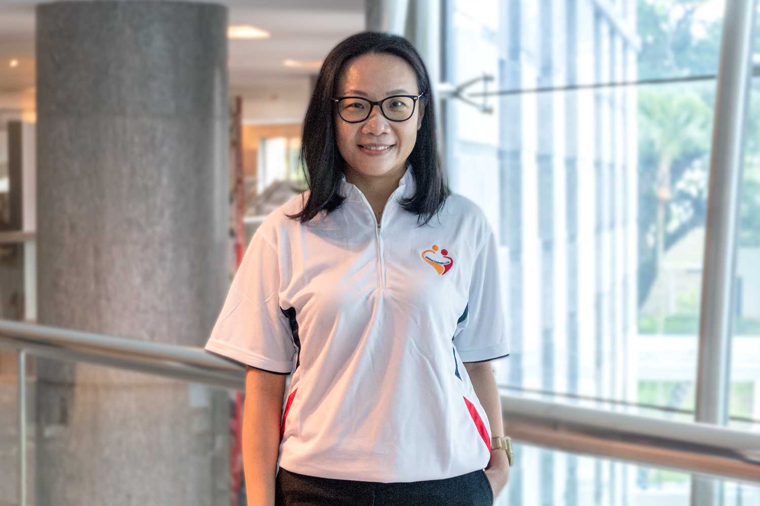 Deputy Chairperson of the Paracounsellor Committee DAC Tay Wee Li stands smiling and looking at the camera. 