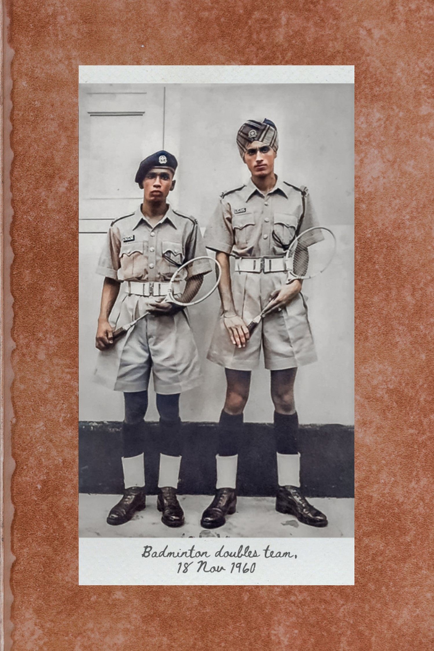 a sikh officer on the right standing with his colleague who is on the left, holding badminton rackets