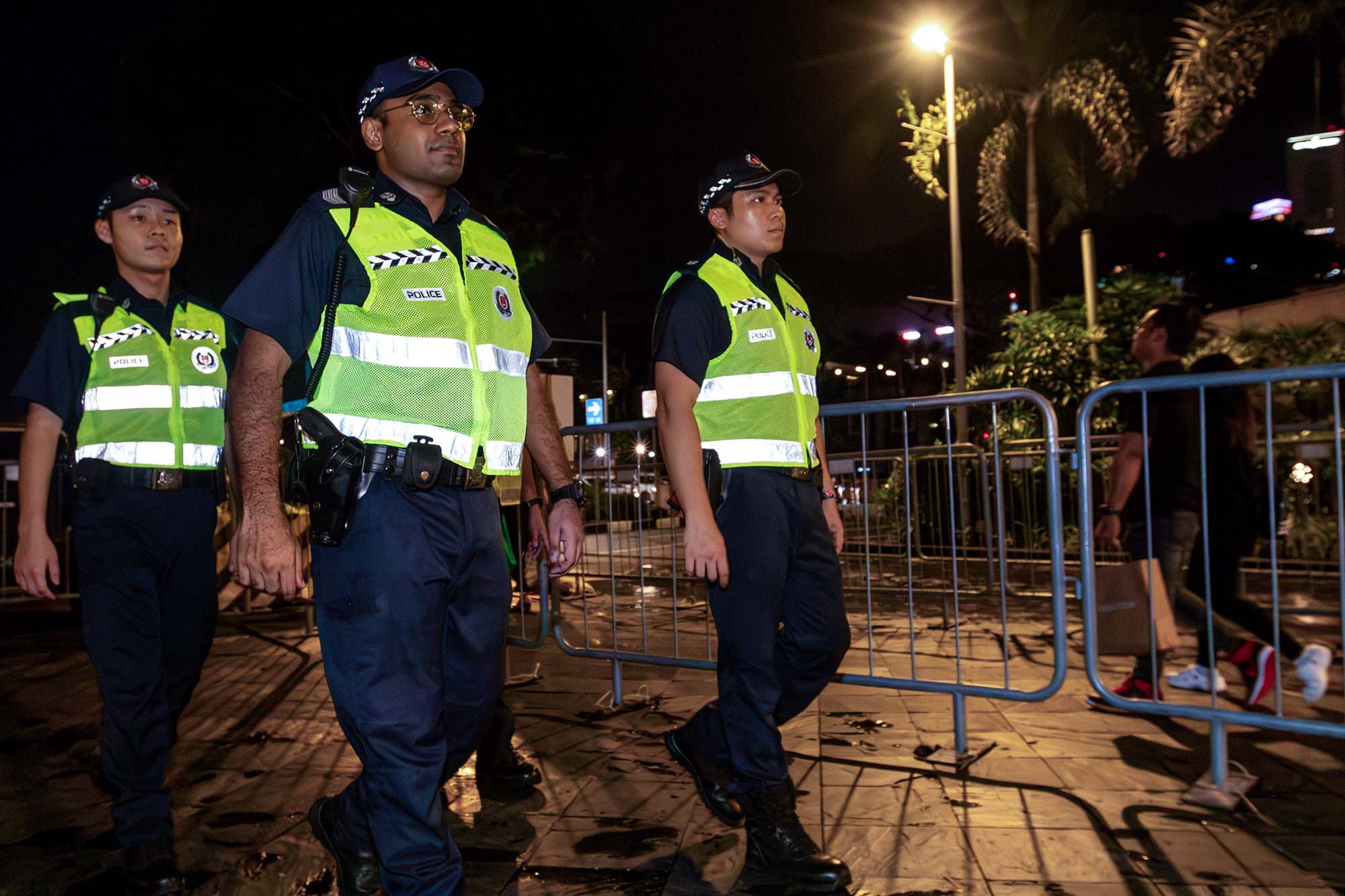 officers patrolling along the road with green vests at night