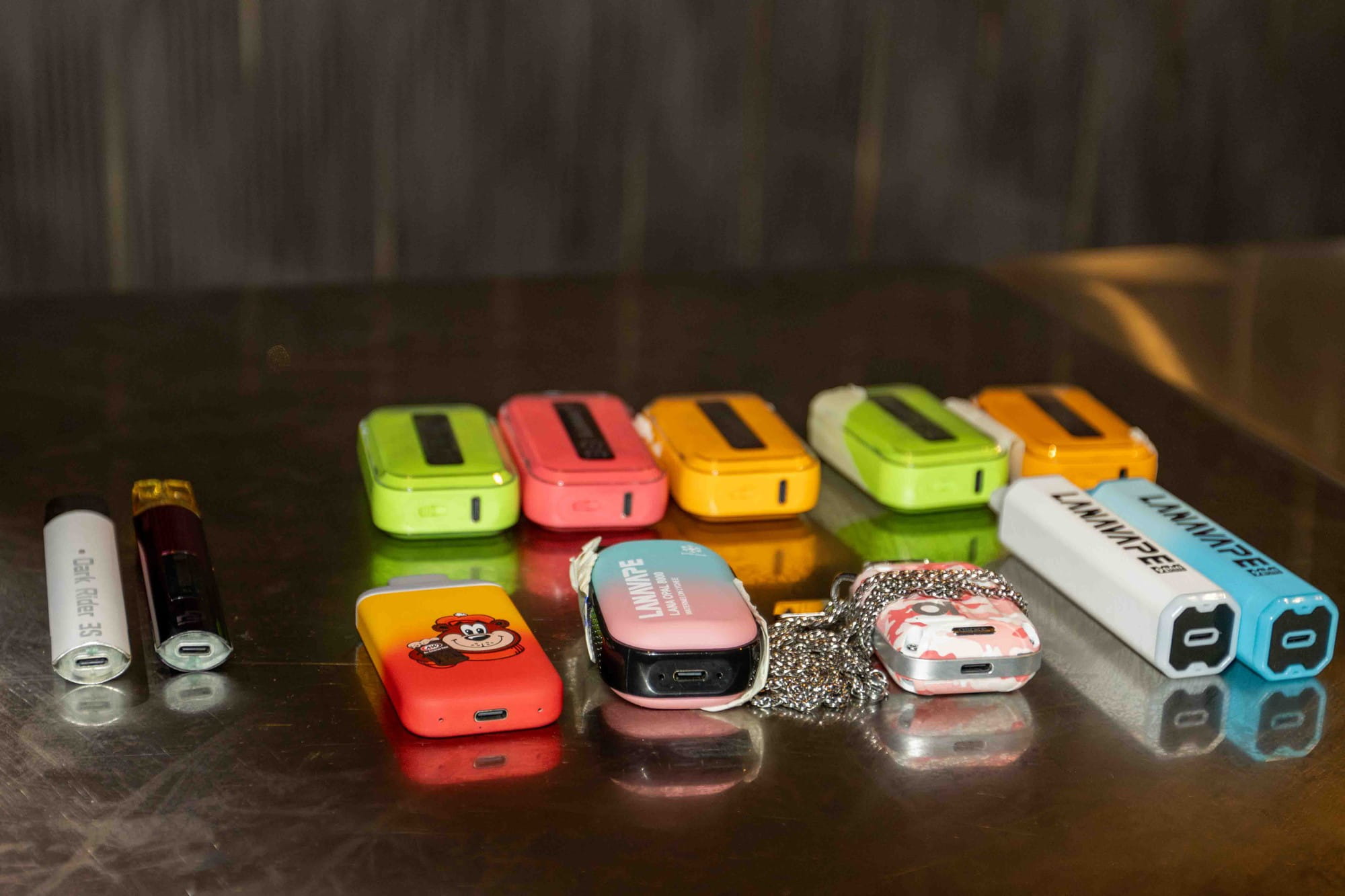 many different coloured vape devices placed on a table