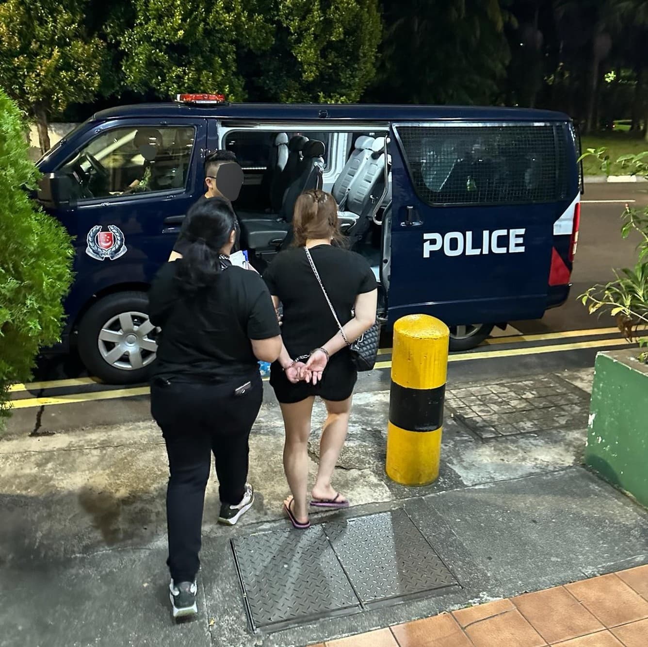 a woman being escorted to a police van