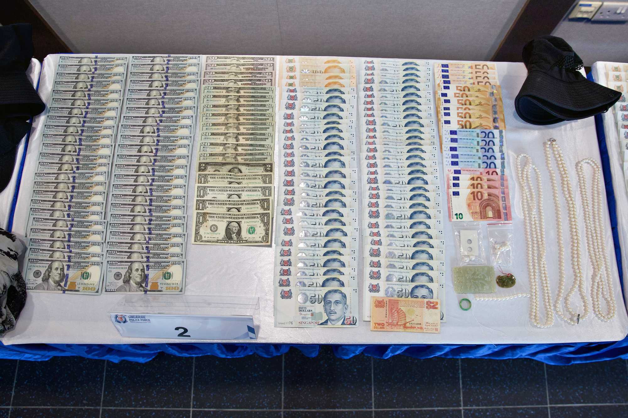 case evidence photographed on the table, involving money and jewellery 