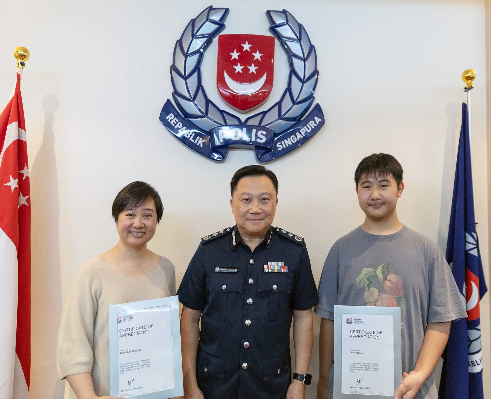 the two members of the public receiving their award from the commander