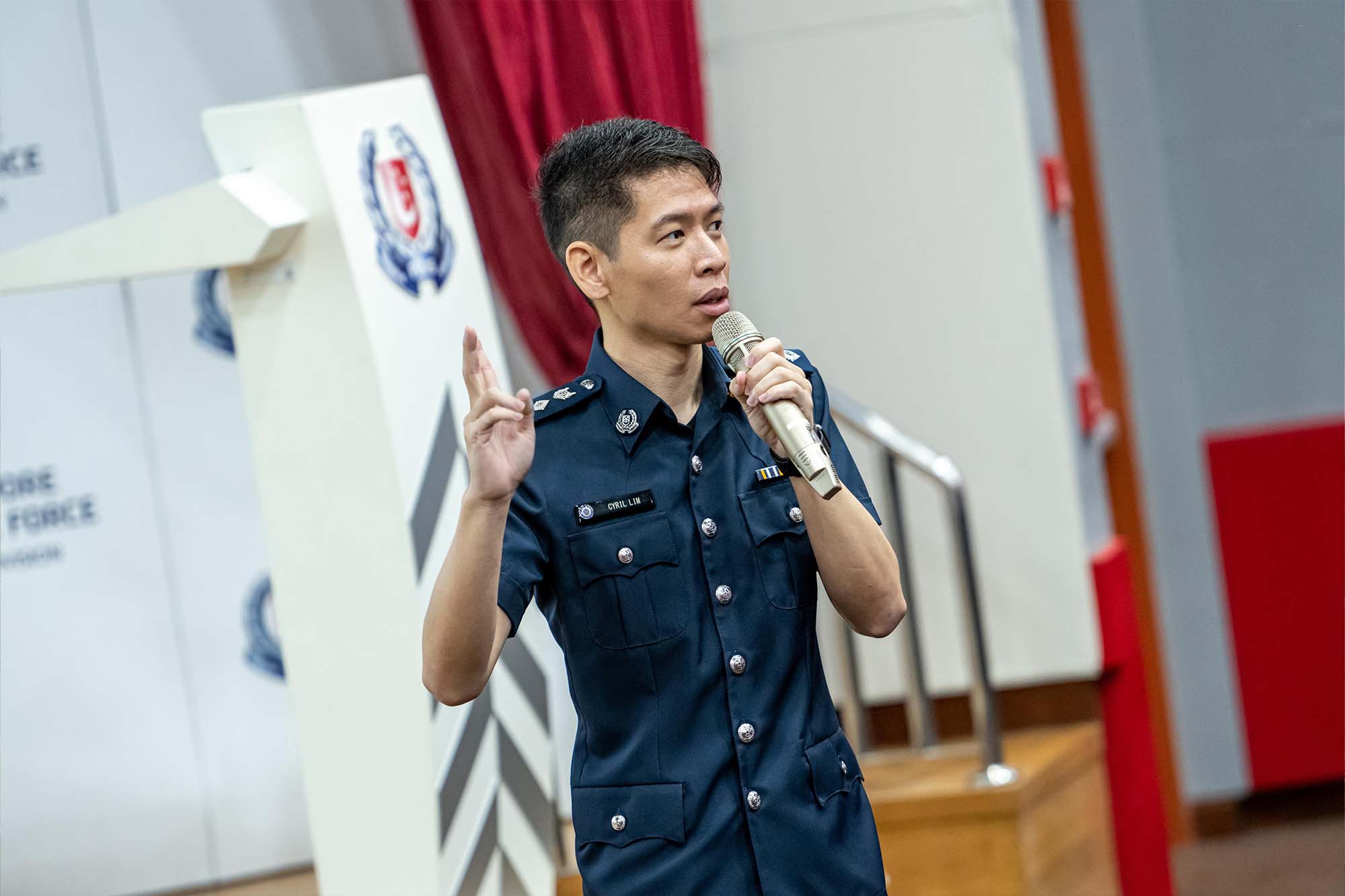 a photo of commander standing and briefing people in a room. He is wearing his police blue uniform