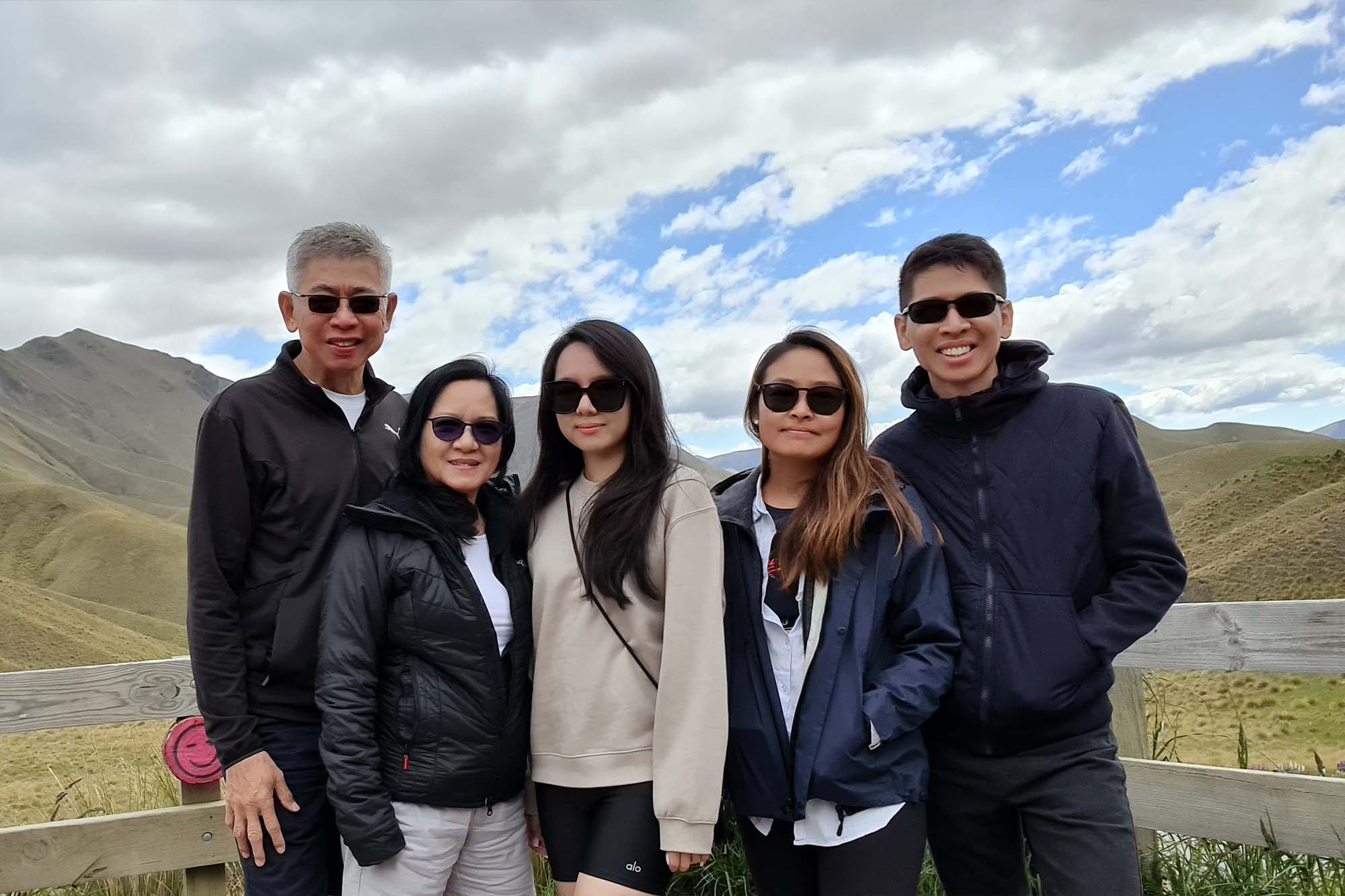cyril on the left, with his wife and his sister and his mother and his father, standing at a mountainous area, and wearing winter wear