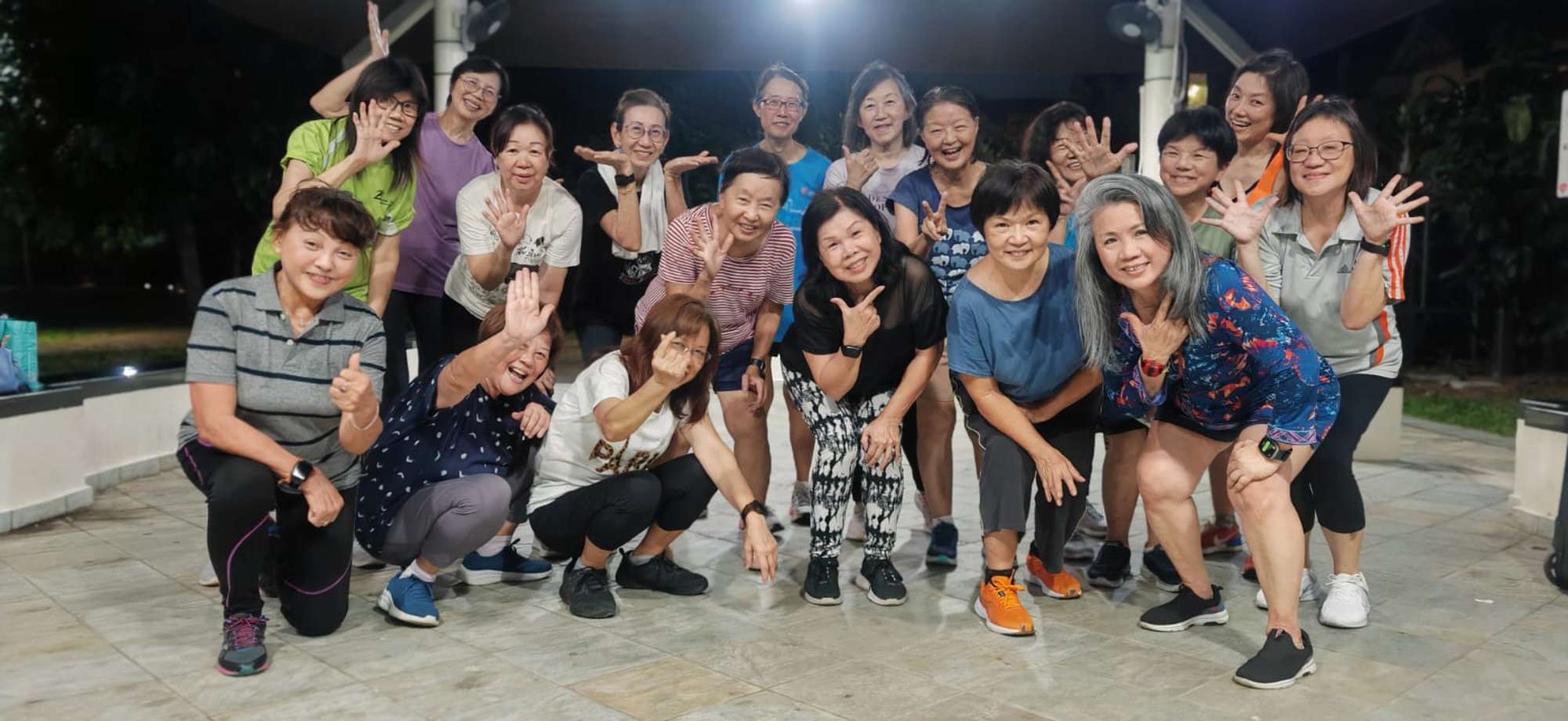 a group photo of senior citizens together posing for the camera. All are wearing fitness attire